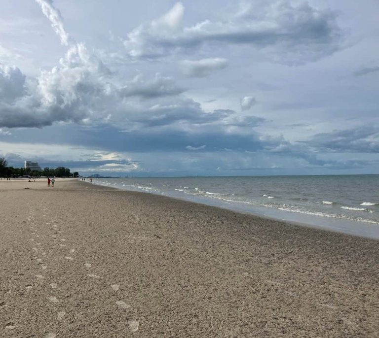 Quiet beach in Hua Hin, Thailand with soft waves, footprints in the sand, and wide open shoreline under a pale sky. This sets a calm reflective mood for a post about what to do in retirement when you are unsure what comes next.